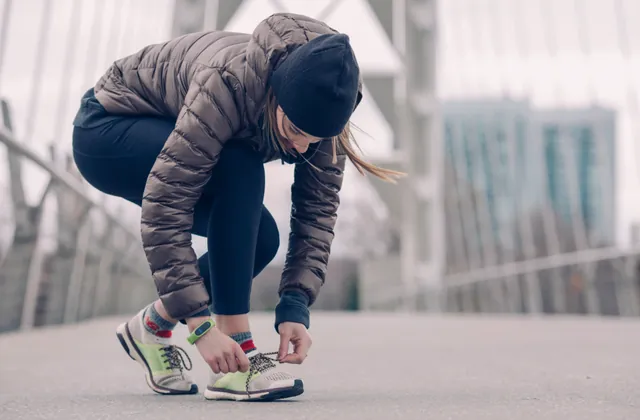 Woman tying running shoes before an outdoor workout