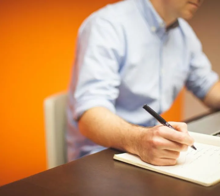 Health writer researching and taking notes at a desk