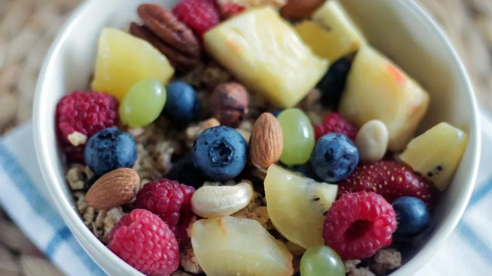 Bowl of mixed fresh fruit and nuts as part of a balanced diet