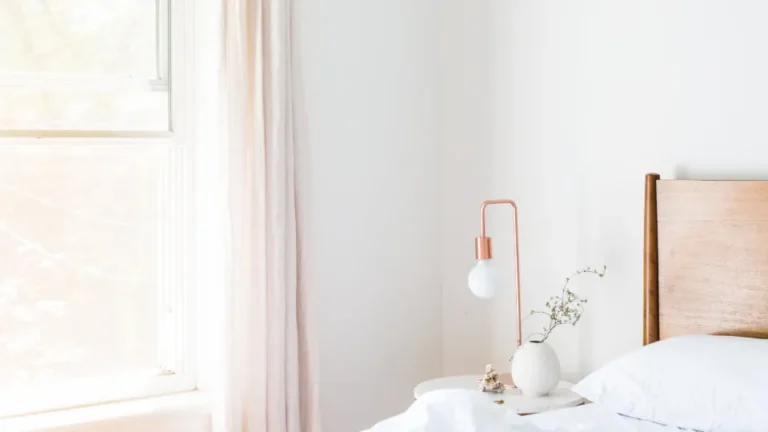 Bright, calm bedroom with white bedding designed for good sleep