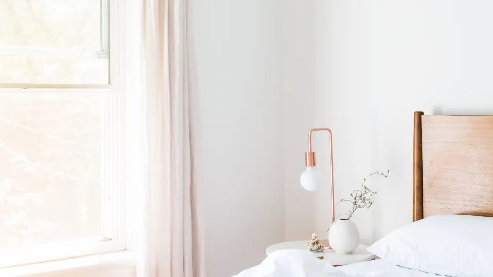 Bright, calm bedroom with white bedding designed for good sleep